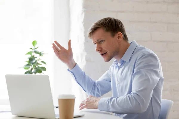 Hombre de negocios irritado teniendo problemas con la computadora gesticulating se siente enojado — Foto de Stock