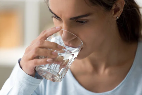 Закройте женское лицо, держа стакан воды — стоковое фото