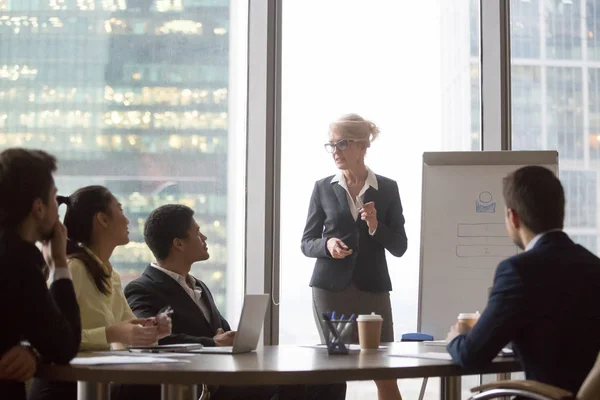 Ejecutivo de mediana edad dar conferencia de presentación para diversos equipos corporativos — Foto de Stock