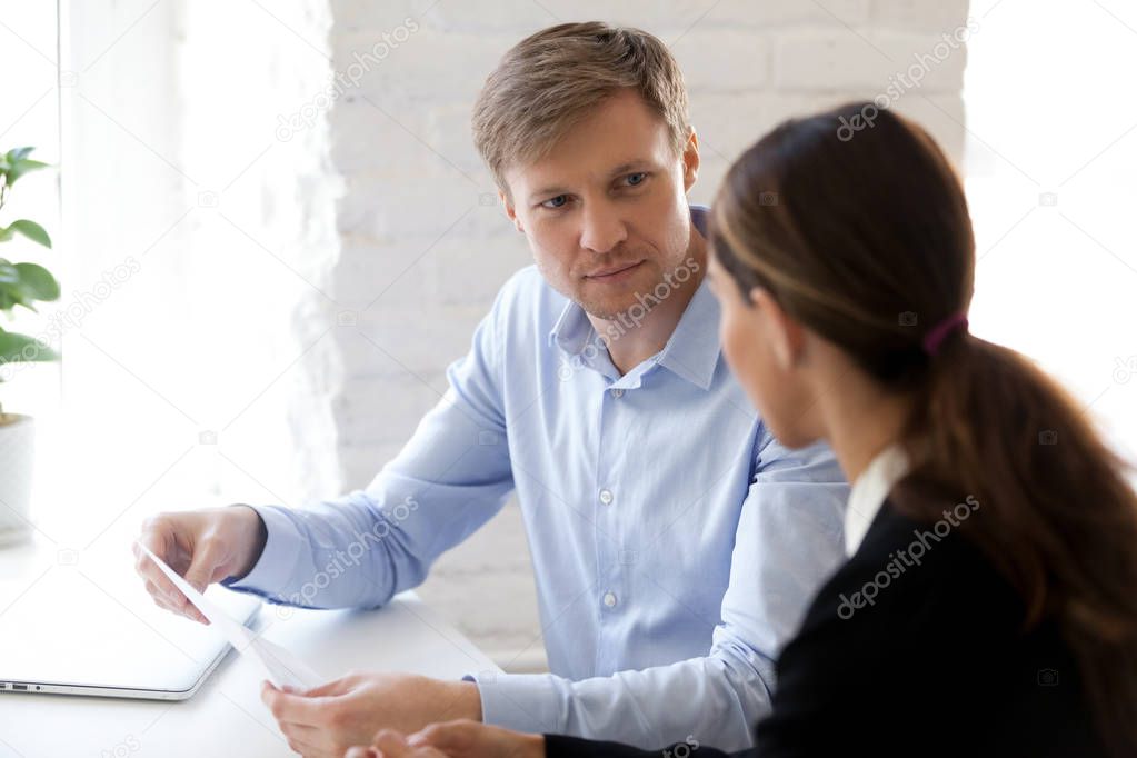 Hr manager and applicant sitting at desk during job interview