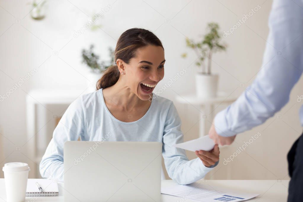 Excited employee receiving from boss envelope with money