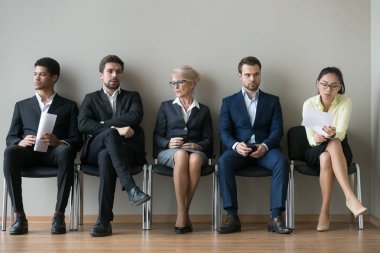 Çeşitli iş adamları başvuru satır iş için bekleyen oturuyor ve röportaj