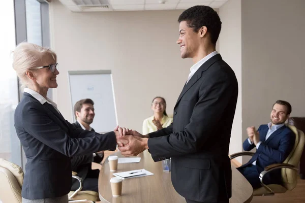 Afrikaanse manager die hand van succesvolle Kaukasische werknemer uitdrukkelijk respect — Stockfoto