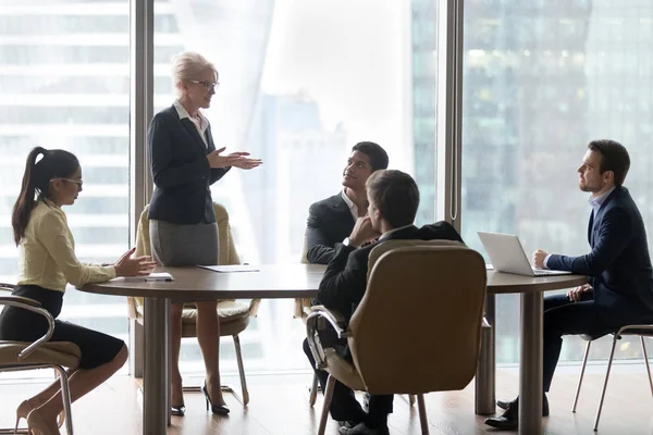 Mature female manager speaking to executive team at group meeting — Stock Photo, Image