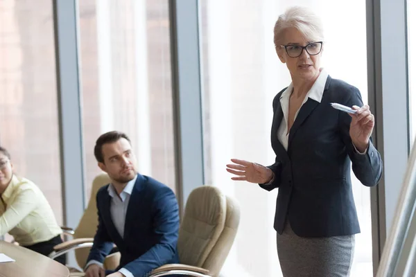 Confident middle-aged mentor speaking giving presentation at executive team training — Stock Photo, Image