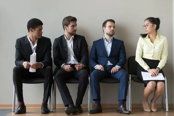 Diverse male applicants looking at female rival waiting for interview — Stock Photo, Image