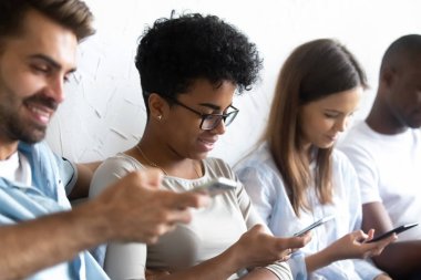 Cep telefonları ile birlikte oturan çok ırklı öğrenciler