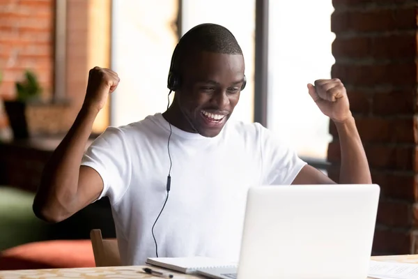 Black young man looking at computer screen feels happy — Stock Photo, Image