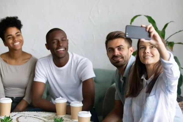 Fyra multiracial vänner sitter i café tar selfie Foto — Stockfoto