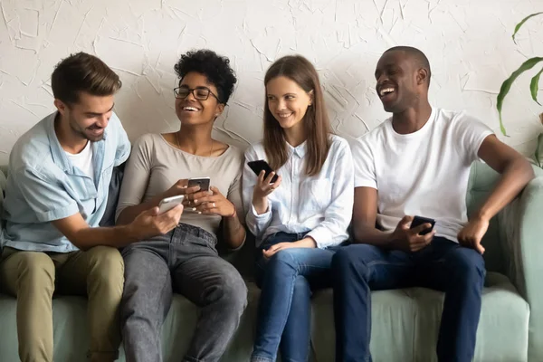 Друзі сміються разом дивитися відео на смартфонах — стокове фото