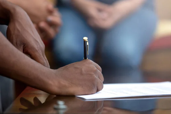 Close up of black man signing contract putting signature — Stock Photo, Image