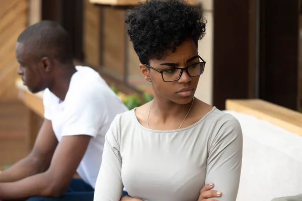 Schwarzes unglückliches Paar sitzt getrennt voneinander auf dem Sofa — Stockfoto