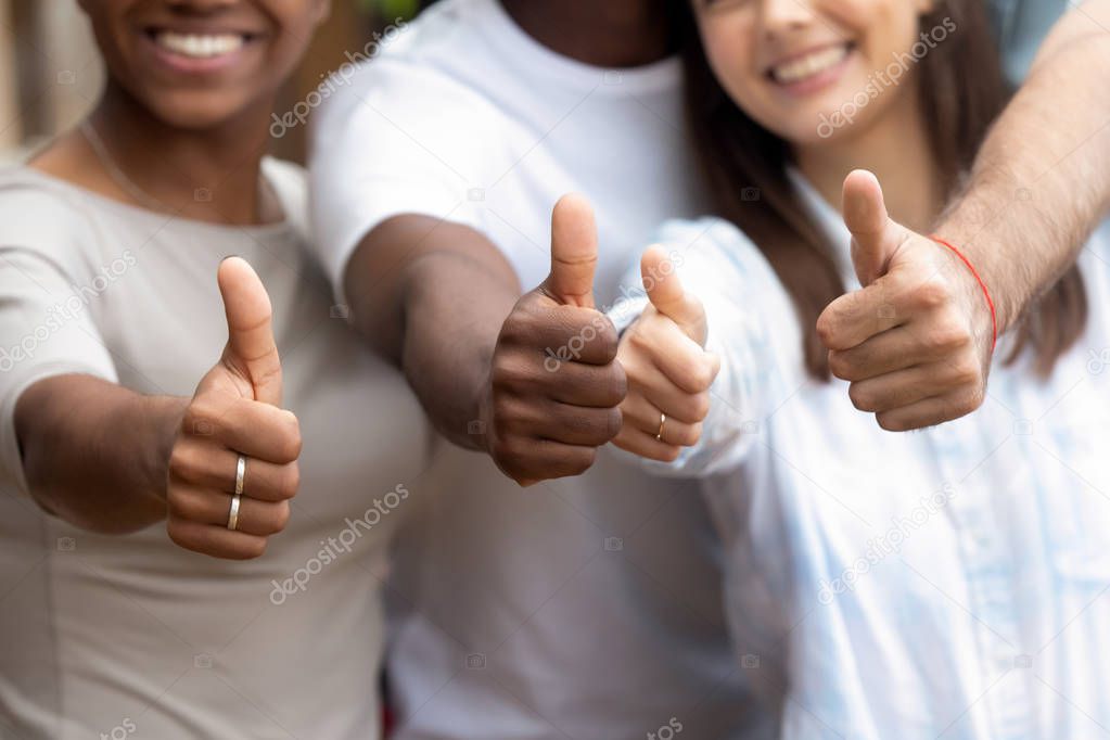 Close up diverse people showing thumbs up
