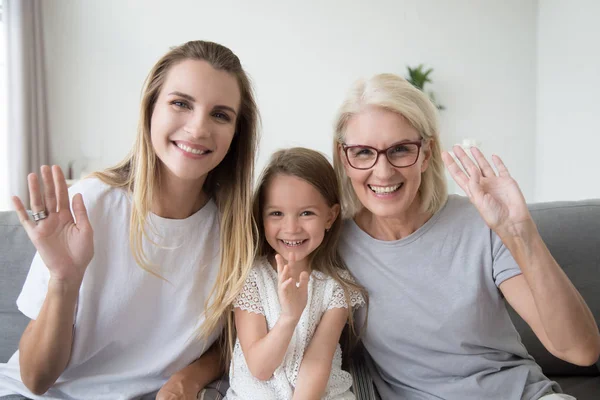 Happy usměvavá holčička s matkou a babičkou, mává rukou — Stock fotografie