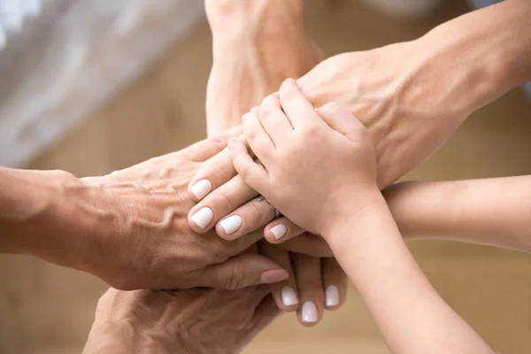 Top weergave drie generaties toetreden hands, aanduiding van de eenheid en ondersteuning — Stockfoto