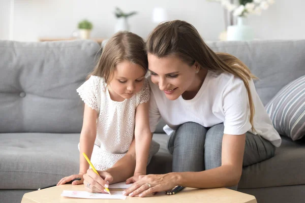 Madre sonriente con dibujo de hija preescolar con lápices de colores — Foto de Stock