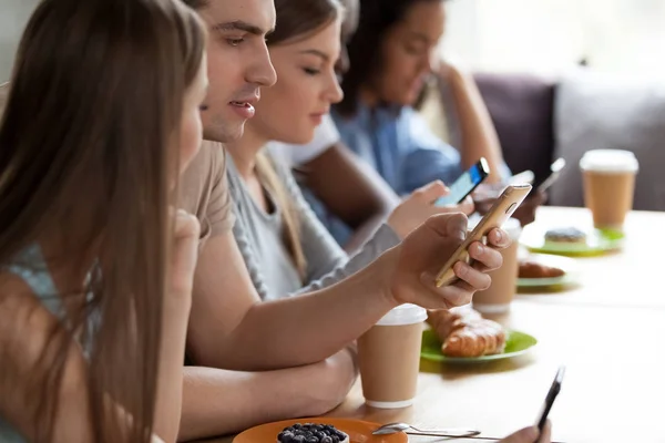Verschillende vrienden zitten in Cafe, met behulp van telefoons, negeren elkaar — Stockfoto
