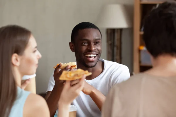 友人とのおしゃべり、アフリカ系アメリカ人の男性が食べてピザを笑顔 — ストック写真
