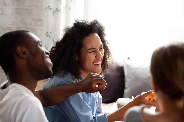 Felice ridendo donna razza mista mangiare pizza, parlando con gli amici — Foto Stock