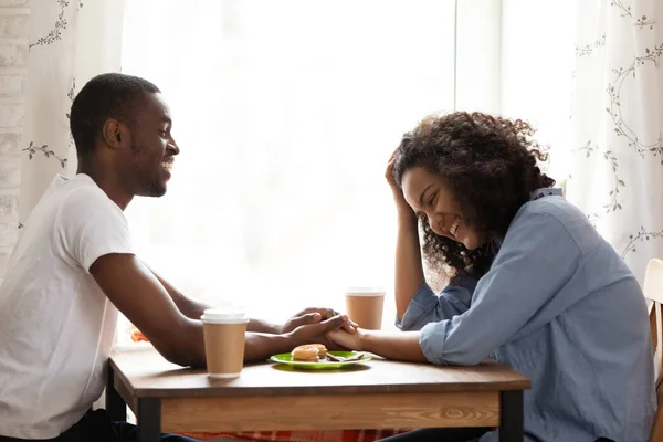 Feliz hombre afroamericano en la fecha con novia atractiva en la cafetería — Foto de Stock