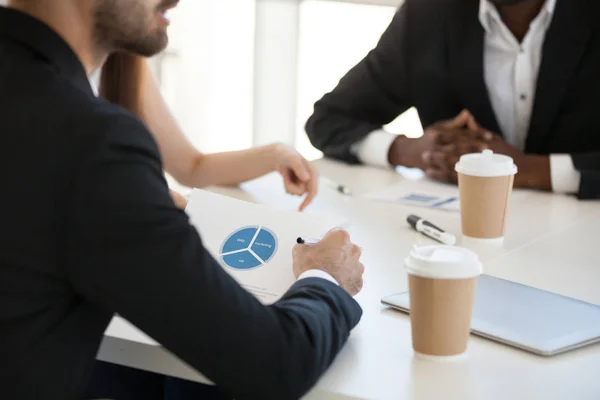 Equipo sentado en el escritorio analizando estadísticas informe financiero durante la reunión — Foto de Stock