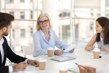 Brifing meslektaşları ile oturan olgun takım lideri