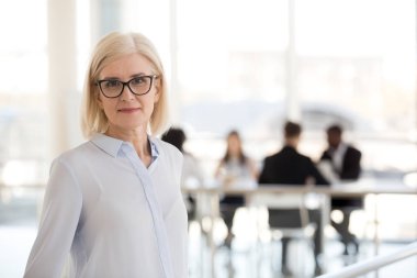 Kafa yaşında şirket sahibi kendine güvenen kadın çalışanların kameraya bakarak ayrı ayakta vurdu. Deneyimli işçi, iş coach modern ofiste poz. Liderlik ve başarılı iş kadın kavramı