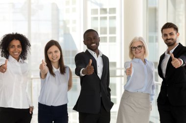 Mutlu çeşitli iş adamları başparmak gösterilmesini kamera bakıyor ayakta