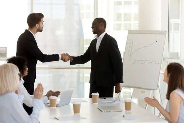 Diverse businessmen standing in office and shaking hands — Stock Photo, Image