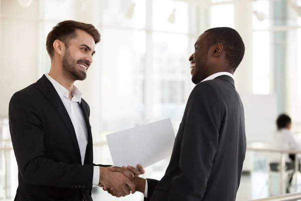 Diversos empresarios positivos estrechando la mano antes de negociar —  Fotos de Stock