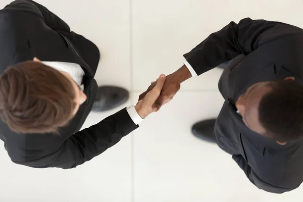 View directly from above diverse businessmen in suits shaking hands — Stock Photo, Image