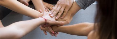 Horizontal close up image caucasian people holding stacking hands together