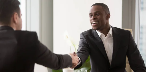 Imagen horizontal empresarios negros y caucásicos iniciando negociaciones estrechando la mano — Foto de Stock