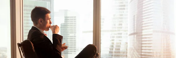 Horizontale Ansicht Entspannter Geschäftsmann sitzt beim Kaffeetrinken und schaut zum Fenster — Stockfoto