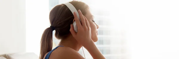 Side view female wearing headphones enjoy favorite music at home — Stock Photo, Image