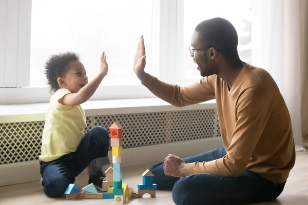 Feliz negro papá y niño hijo dando chocar cinco jugando juntos —  Fotos de Stock