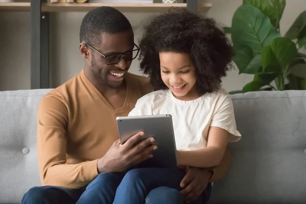 Feliz padre africano e hija niño usando tableta digital —  Fotos de Stock