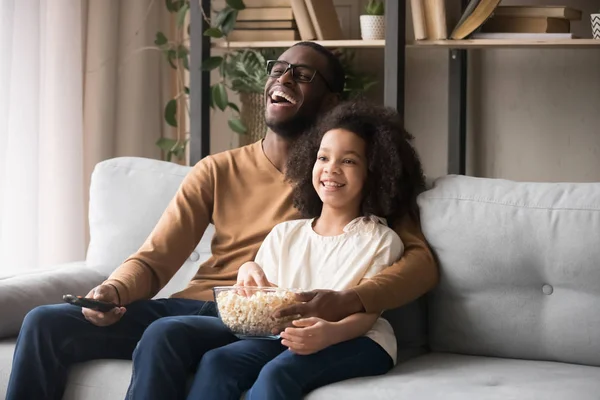 Alegre afro-americano pai e criança menina rindo assistindo tv — Fotografia de Stock