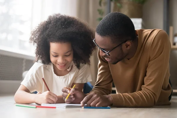 Zorgzame zwarte vader tekenen met kleurpotloden onderwijs kind meisje — Stockfoto