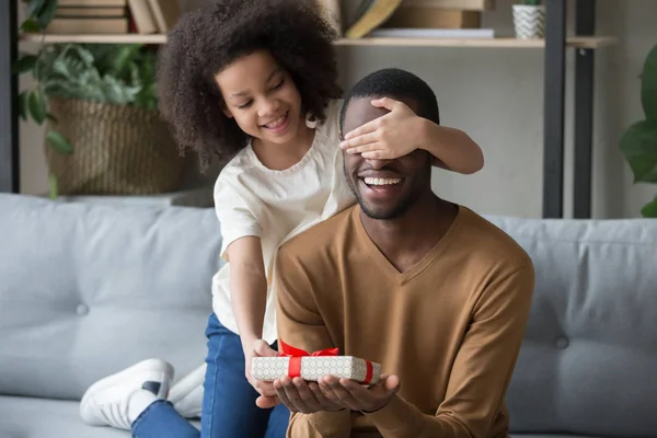Africano niño hija cierre ojos felicitando papá dando regalo caja —  Fotos de Stock