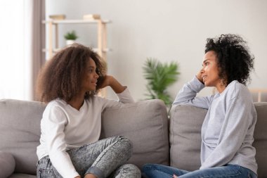 Afrika genç anne dinleme genç kızı kanepede birlikte oturan