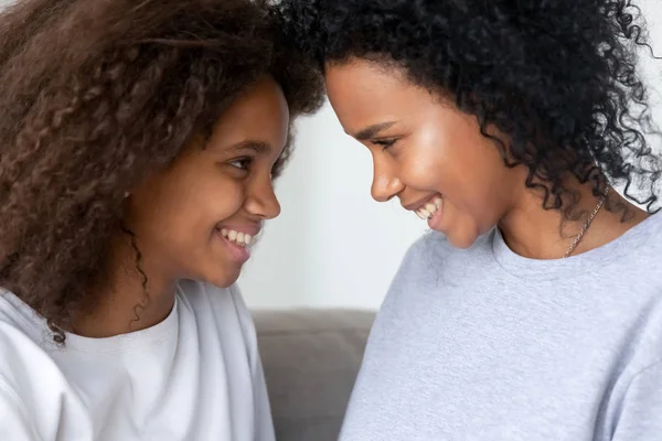 Svart dotter och mor tittar på varandra och ler — Stockfoto