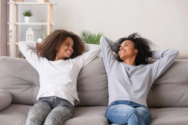 Pozitif siyah anne ve kızı evde kanepede oturan — Stok fotoğraf
