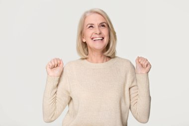Arka plan üzerinde izole kazanmak kutluyor mutlu çok memnun orta yaşlı bir kadın 