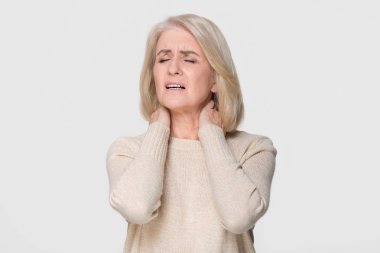 Upset mature woman massage feeling neck pain isolated on background clipart