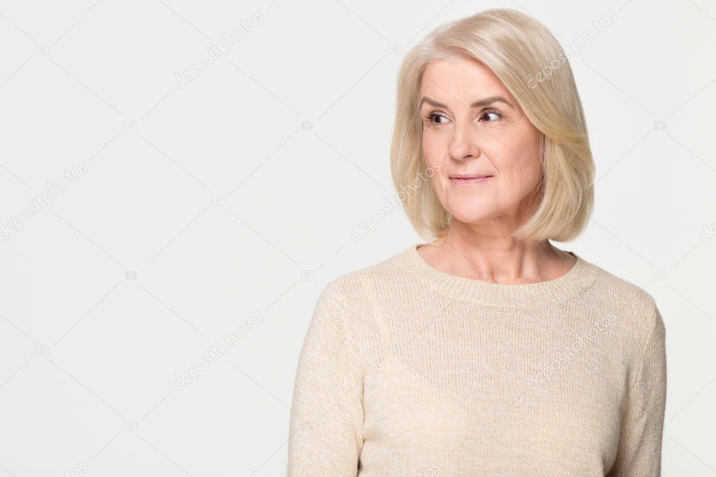 Dreamy mature woman looking at copy space isolated on background