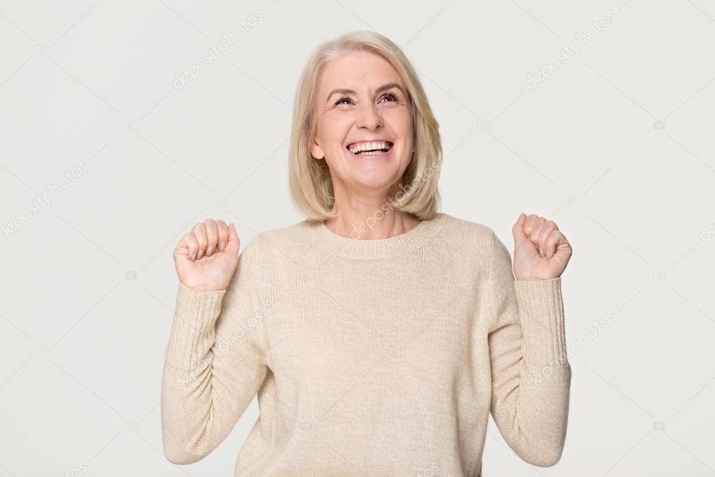 Happy overjoyed middle aged woman celebrating win isolated on background 