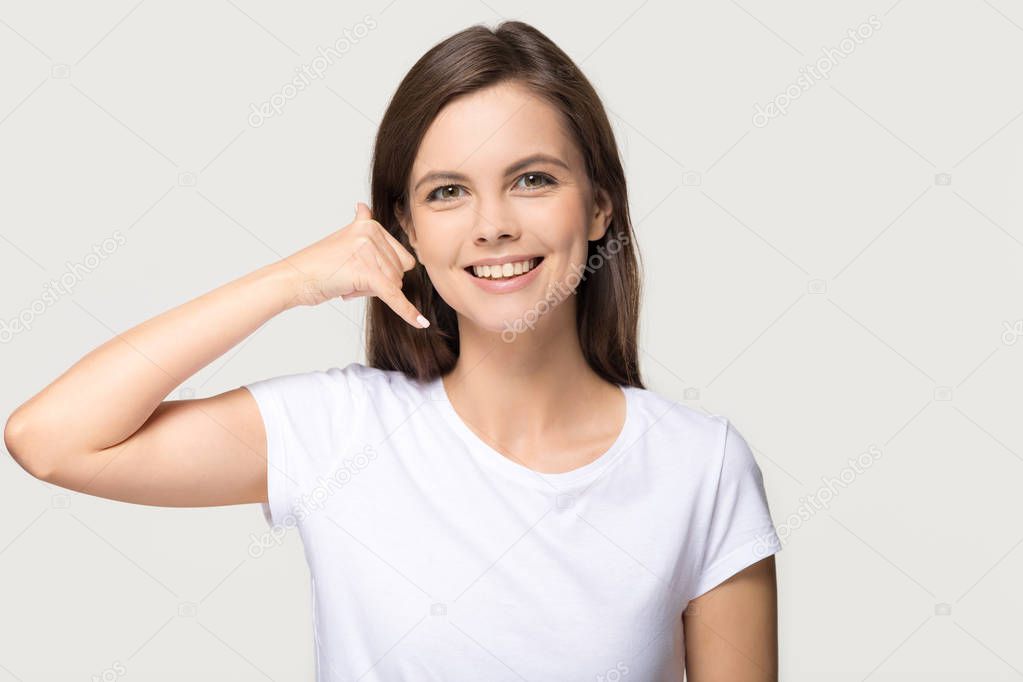 Happy girl showing call me phone gesture isolated on background
