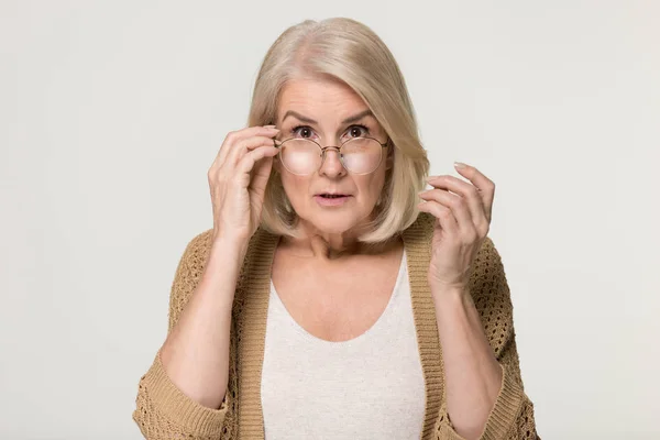 Kameraya bakarak gözlük düşürücü güvensizlik içinde şok yaşlı kadın — Stok fotoğraf