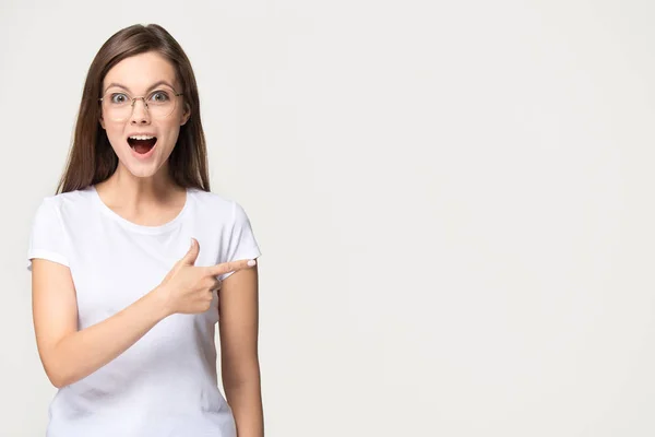 Excited teen girl pointing finger at copyspace isolated on background — Stock Photo, Image